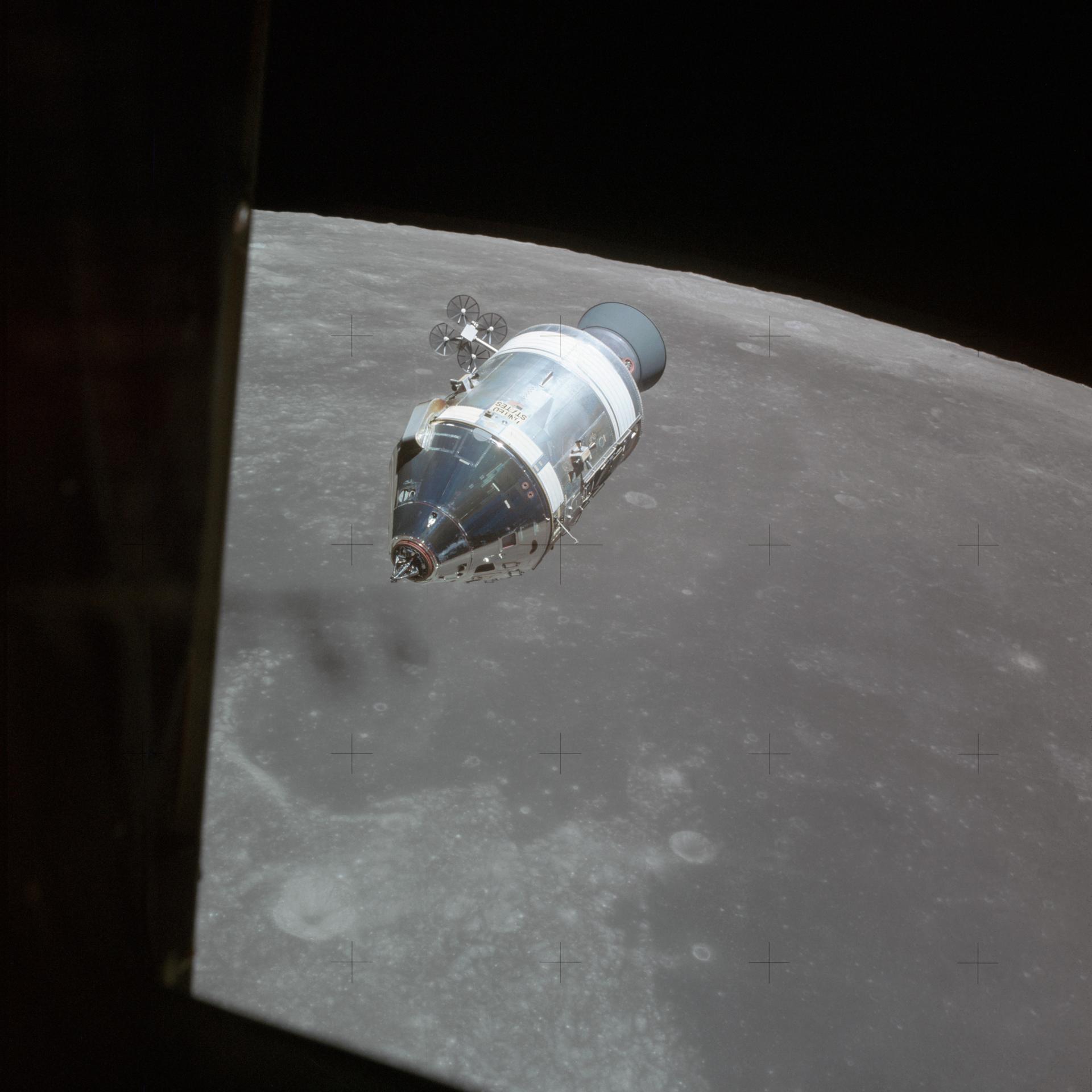 Das Apollo-15-Raumschiff im Mondorbit vor der Mondoberfläche, an der Flanke des Servicemoduls sind die kreuzförmigen Triebwerksgruppen zu erkennen