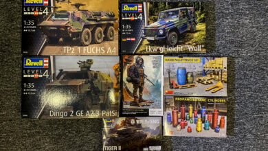 Collection of plastic model kits featuring military vehicles and accessories.