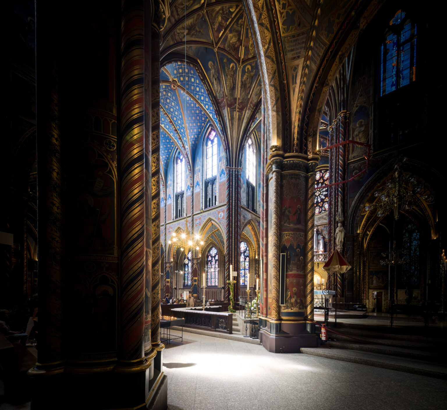 Dunkles Seitenschiff der Marienbasilika in Kevelaer mit Lichtstrahl und gewundenen Säulen