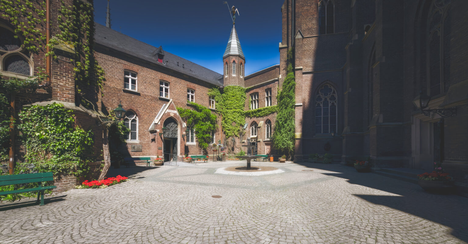Innenhof der Marienbasilika in Kevelaer mit Brunnen und efeubewachsenen Gebäuden
