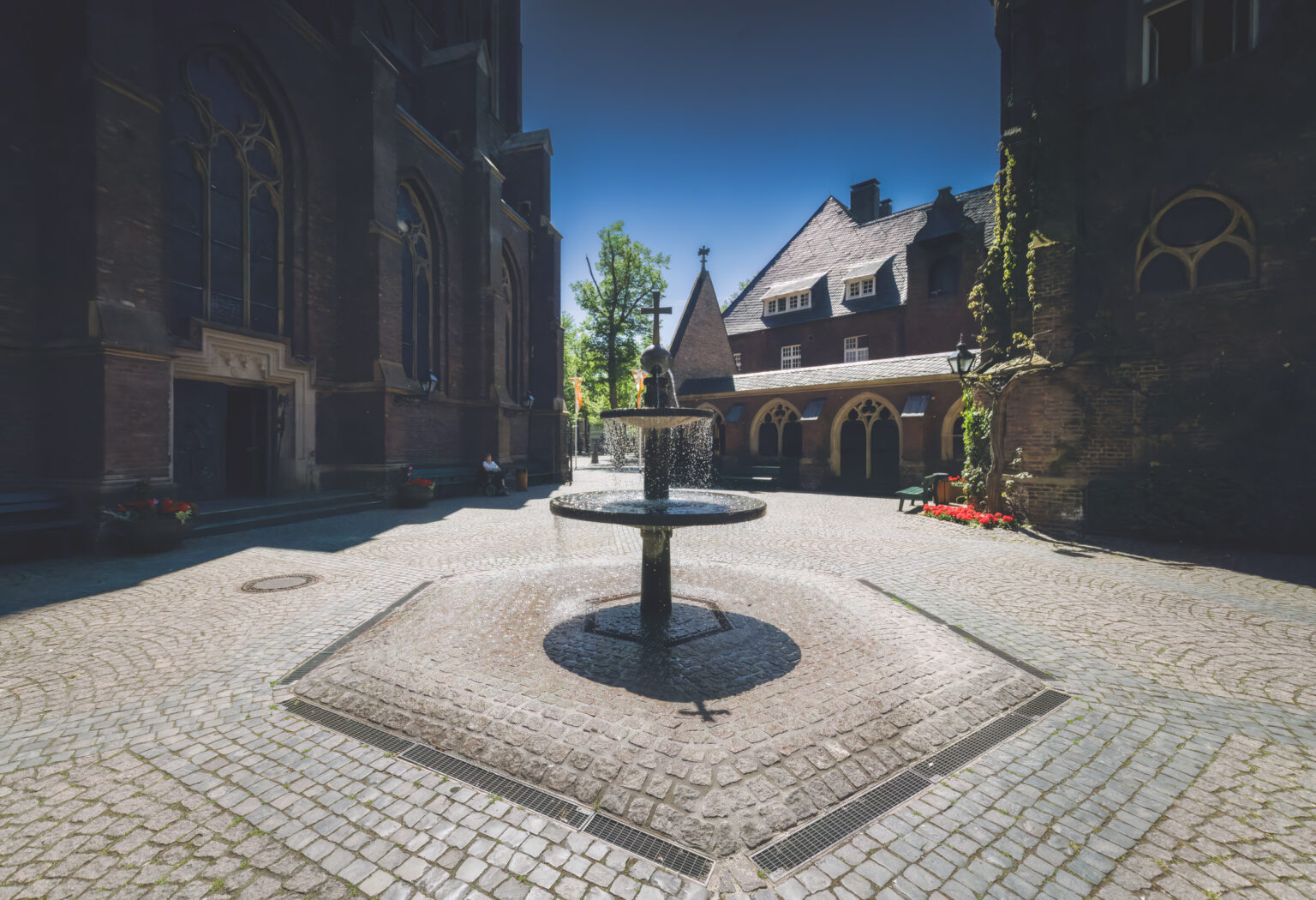 Brunnen im Innenhof der Marienbasilika in Kevelaer mit Backsteingebäuden