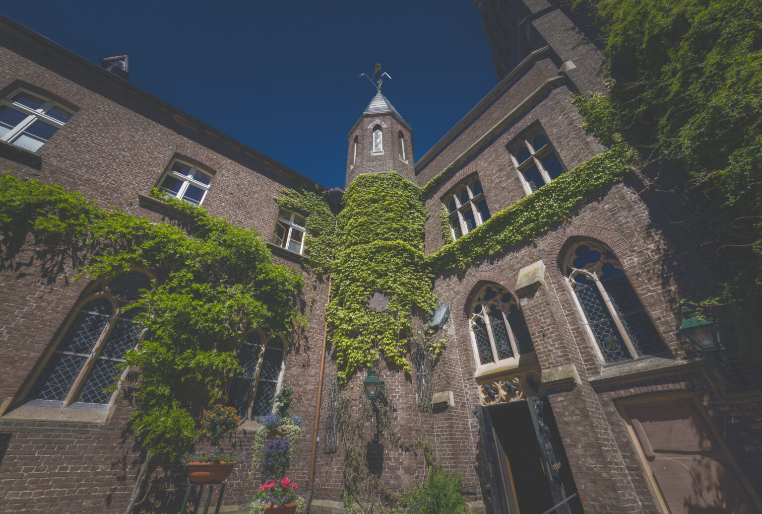 Efeubewachsenes Backsteingebäude der Marienbasilika in Kevelaer mit Türmchen und Marienfigur