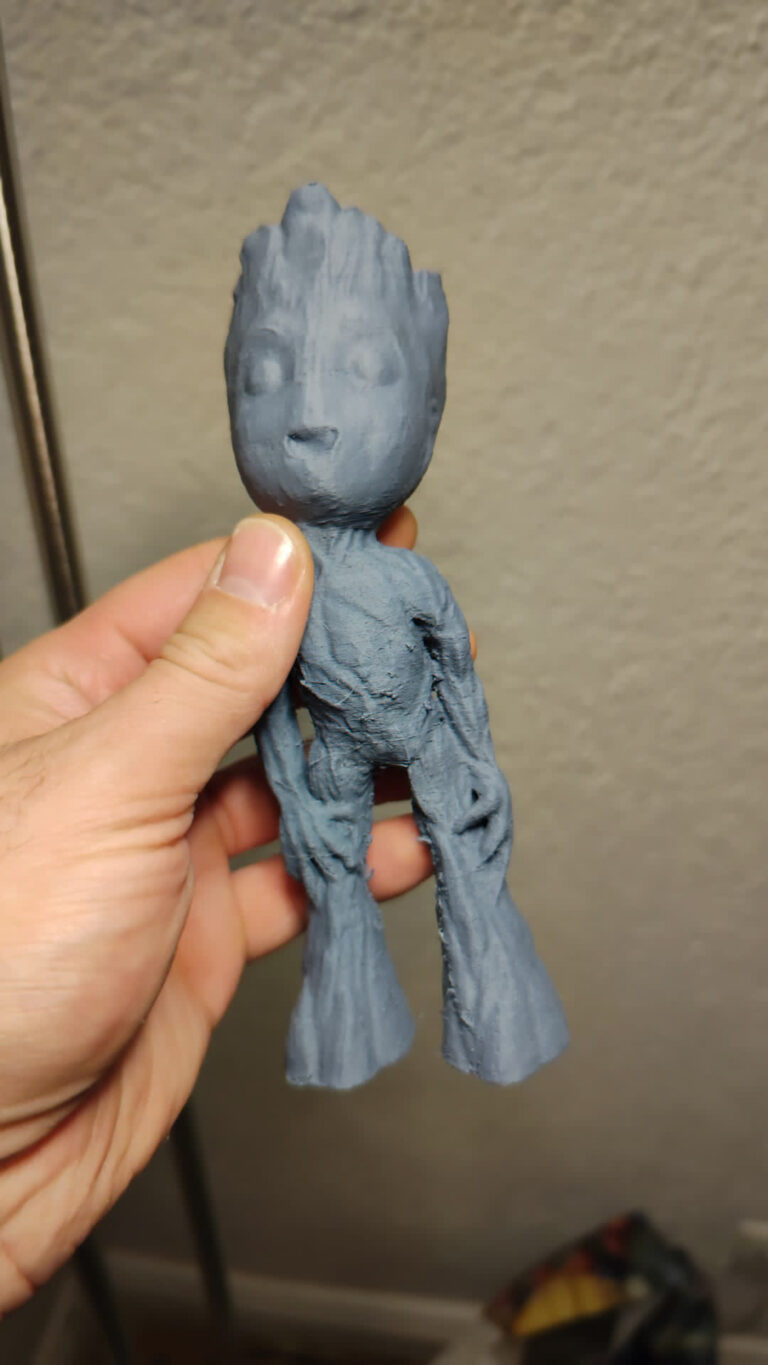Fertig gedruckte graue Baby-Groot-Figur in der Hand gehalten