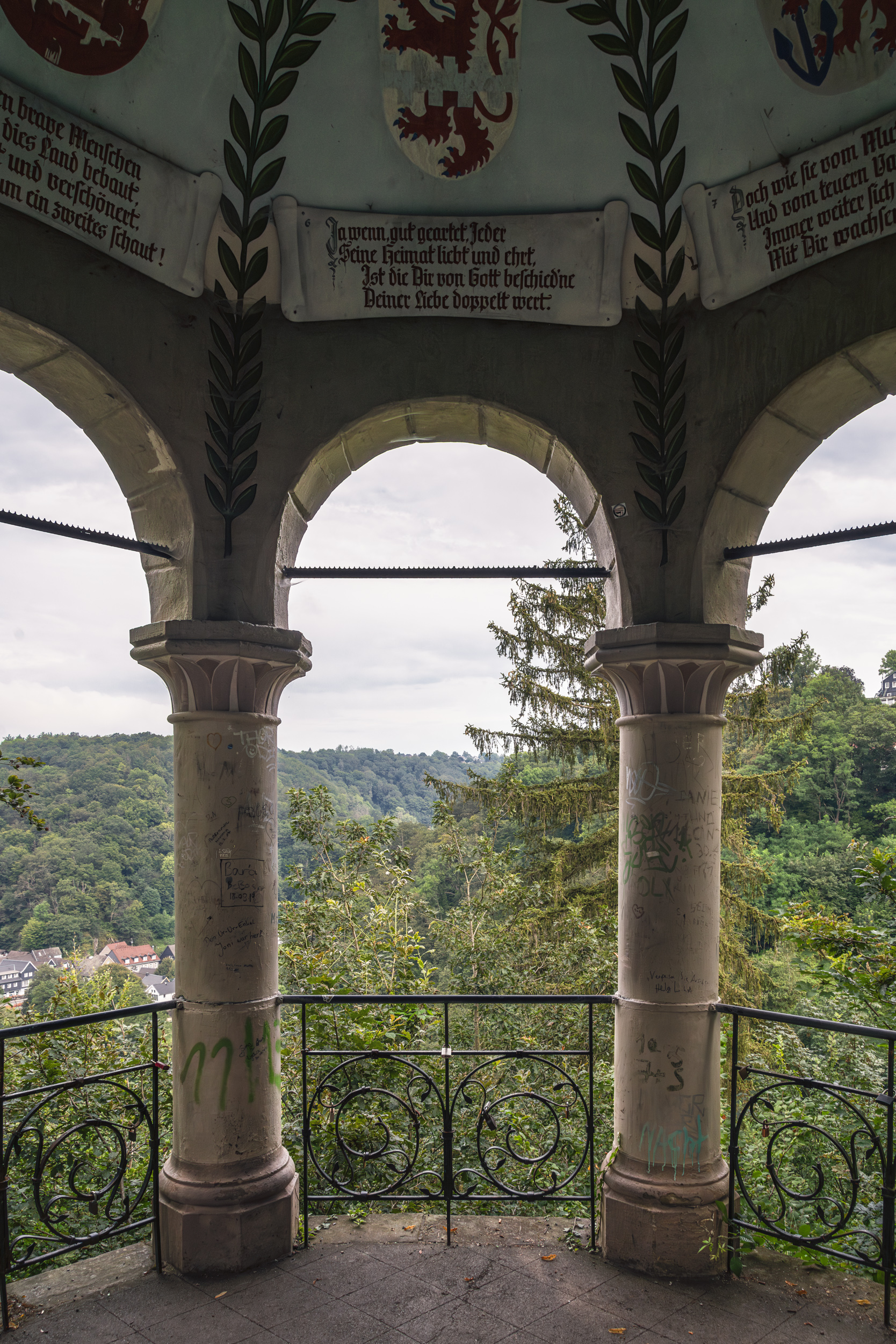 Pavillonbögen mit bemalten Wappen und Talblick ins Bergische Land