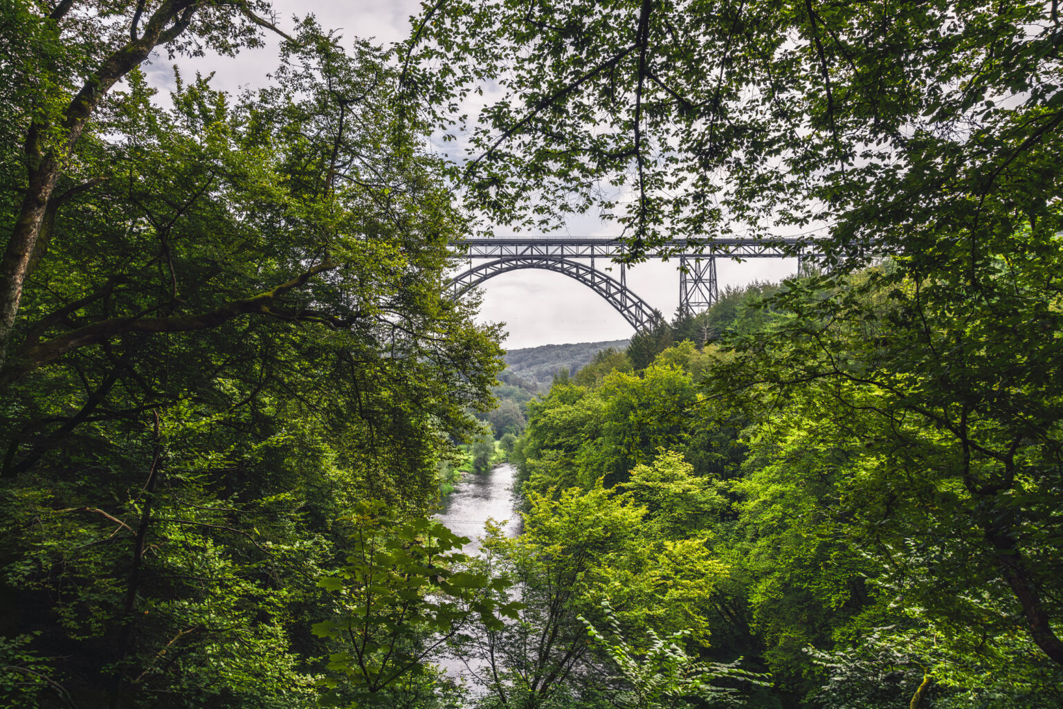 Stählerne Bogenbrücke der Müngstener Brücke über dem bewaldeten Wuppertal