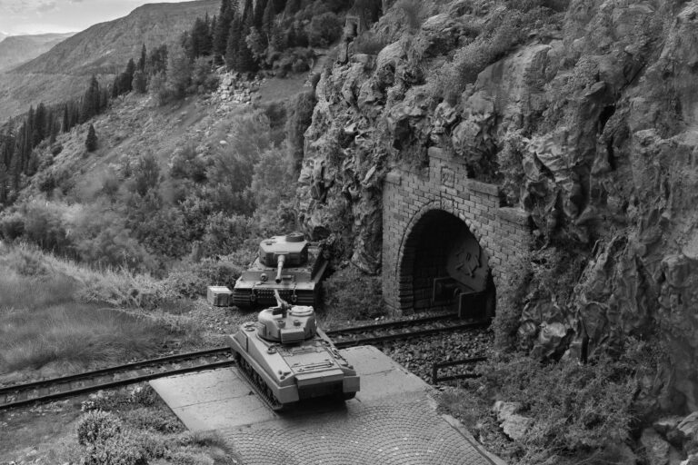 Schwarzweiße Szene des Dioramas mit zwei Panzermodellen am Tunnelportal vor Berghintergrund