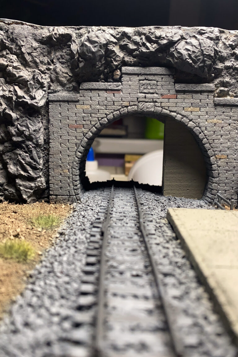 Nahaufnahme durch das gemauerte Tunnelportal des Dioramas mit Gleis und Schotterbett