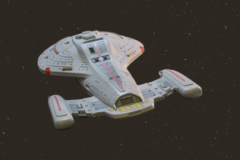 USS-Voyager-Modell in der ventralen Heck-Dreiviertelansicht vor Sternenhintergrund freigestellt