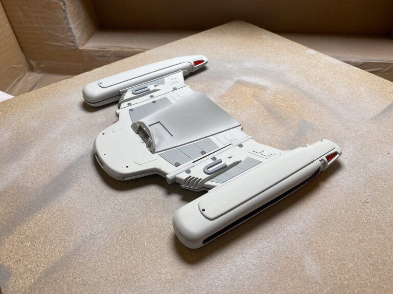 Weiß lackierter USS-Voyager-Sekundärrumpf mit roten Akzenten auf der Schneidematte am Bauplatz