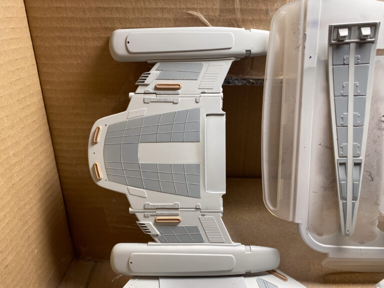 Transparente blaue Deflektor- und Ständerteile des USS-Voyager-Modells auf roter Schale