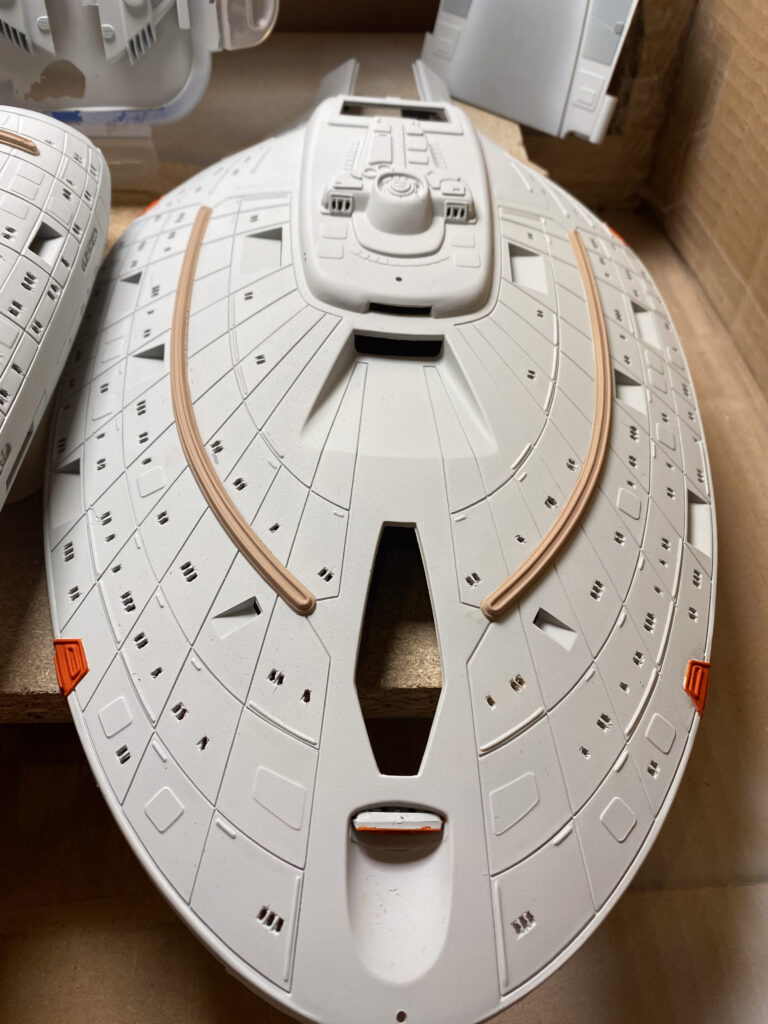 Weiß lackierte Untertassenoberseite der USS Voyager mit Aztec-Muster und orangefarbenen Akzenten im Karton