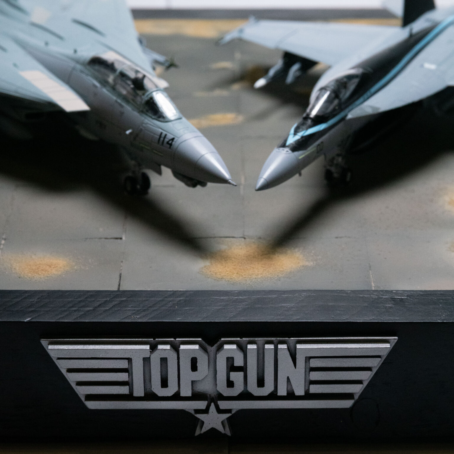 Nahaufnahme der Nasen von F-14-Tomcat und F-A-18-Super-Hornet über dem Top-Gun-Logo