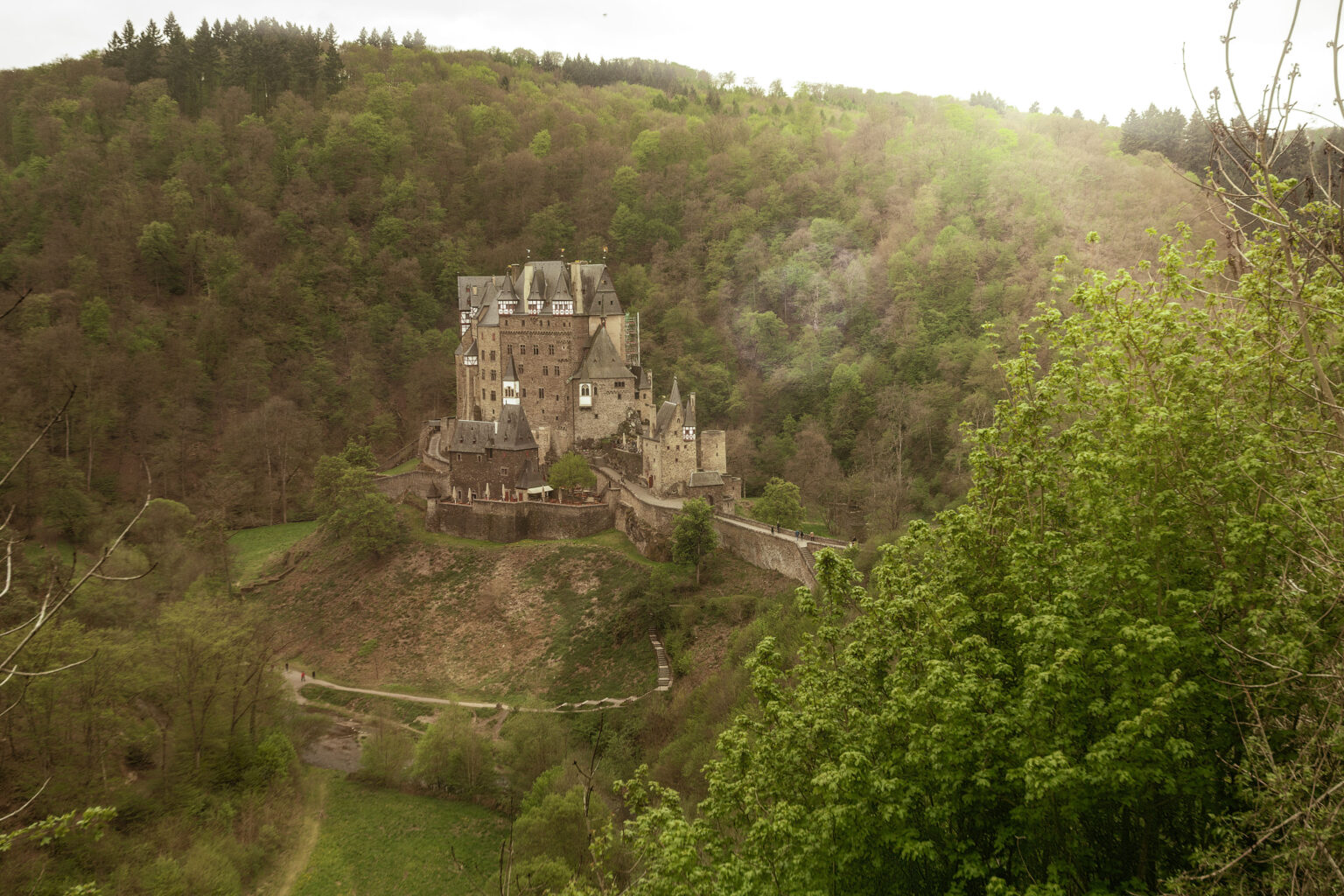 Märchenhafte Burg Eltz, idyllisch gelegen in einem bewaldeten Tal.