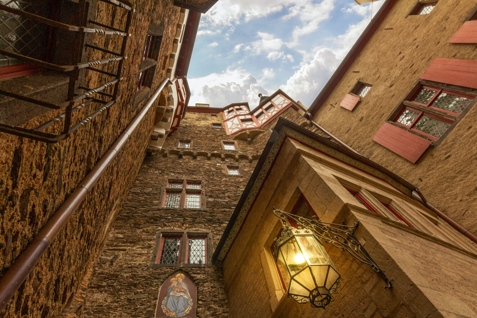 Enge Mauern und Fachwerkgiebel der Burg Eltz gen Himmel.
