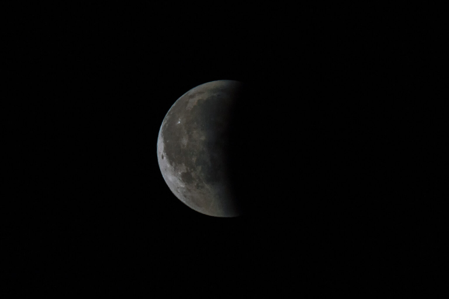 Eine partielle Mondfinsternis am dunklen Nachthimmel.