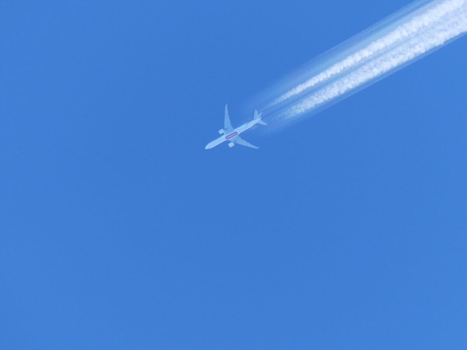 Persistenter Kondensstreifen eines Verkehrsflugzeugs vor blauem Himmel