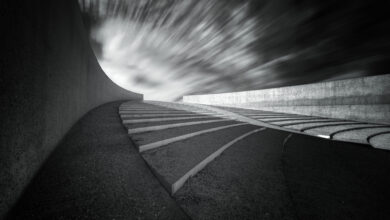 Monumentale Betonarchitektur unter einem dynamischen Himmel.