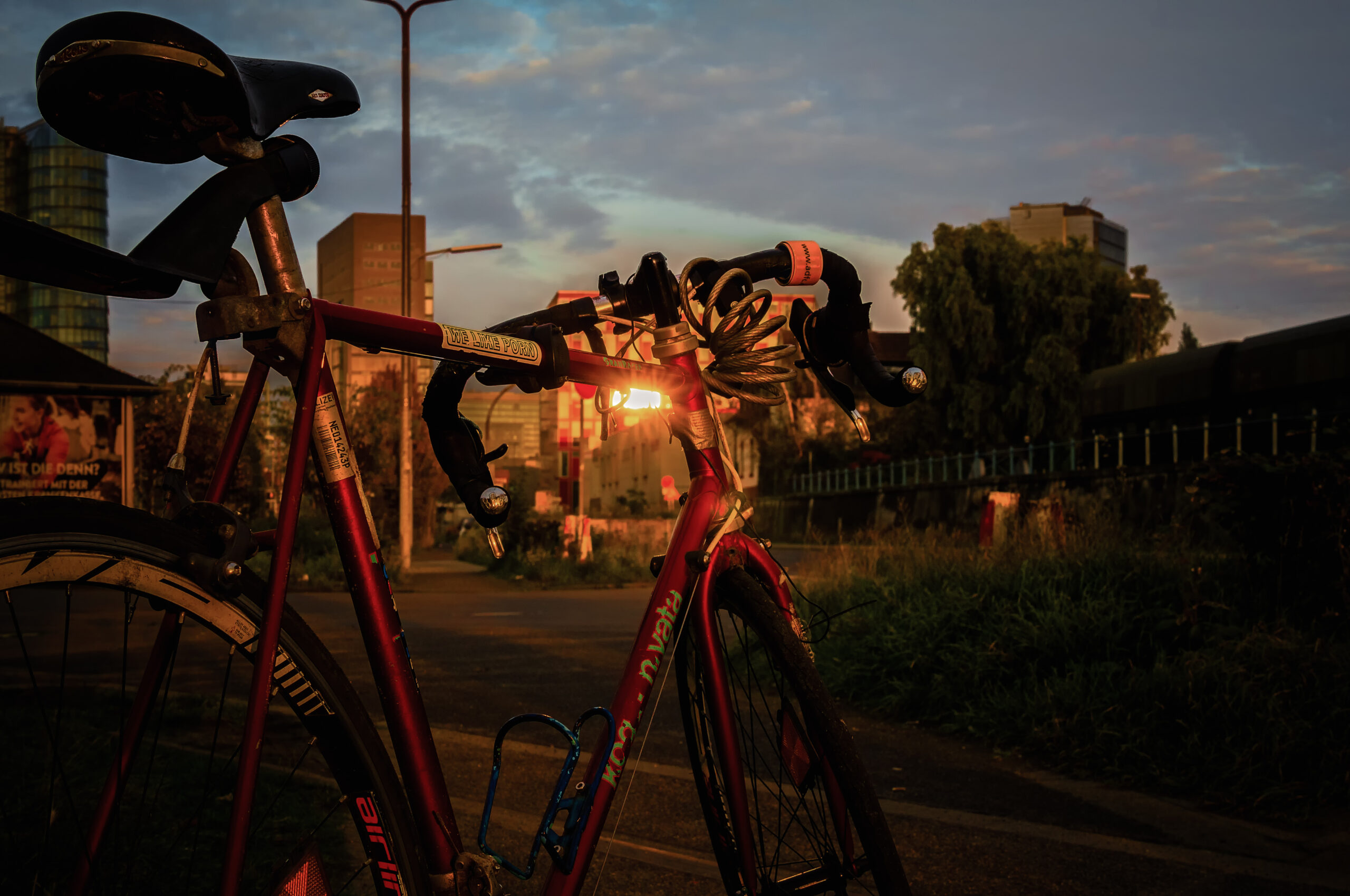 Red road bike against the light at the Düsseldorf harbour, office buildings in the background